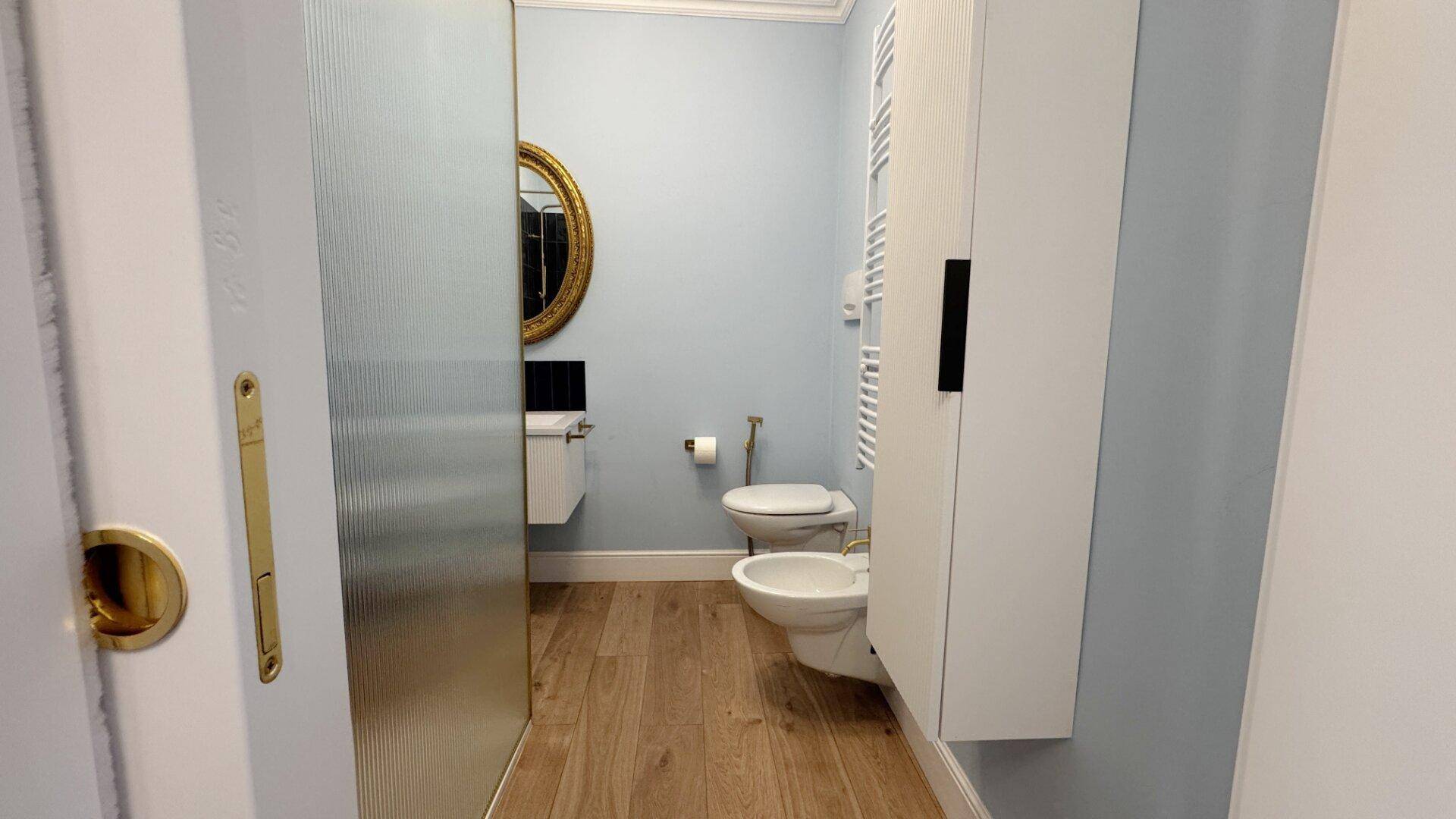 Modernes Badezimmer mit Toilette, Bidet und beheiztem Handtuchhalter.