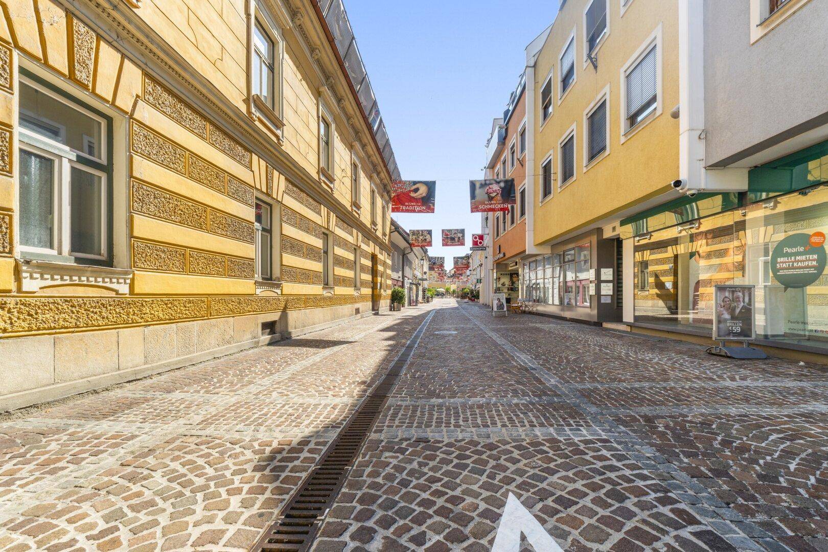Historische Gasse mit Kopfsteinpflaster und traditionellen Gebäuden in der Stadt.