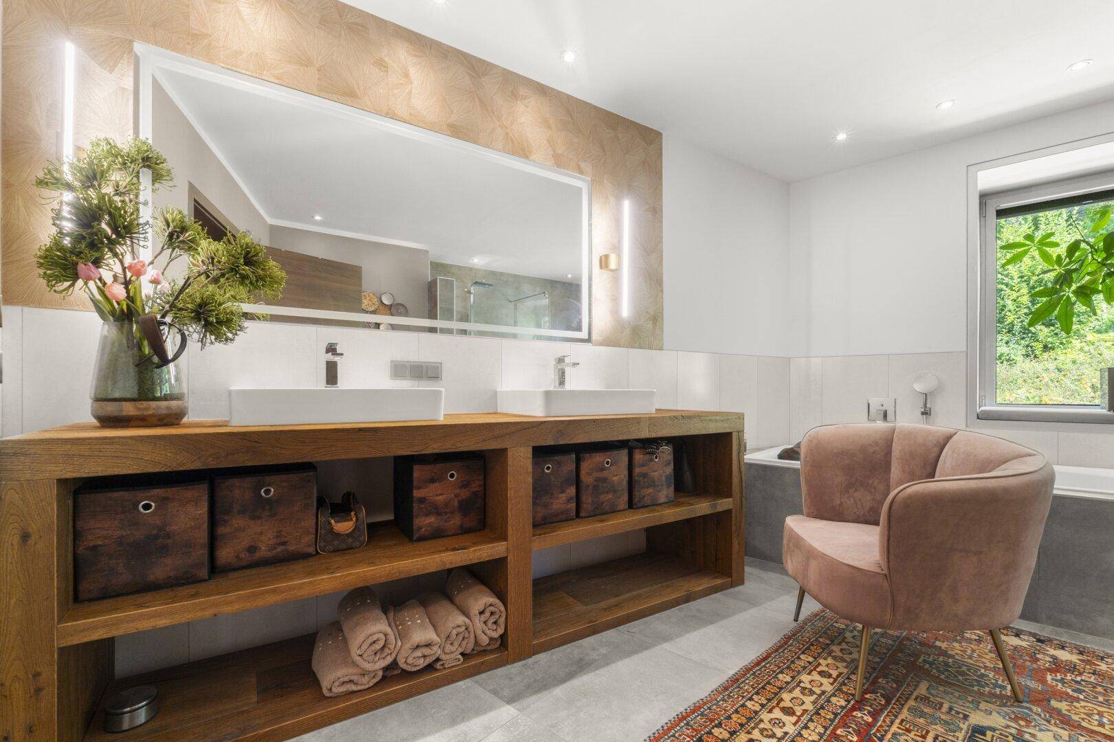 Modernes Badezimmer mit Doppelwaschbecken, Badewanne und großem Spiegel.