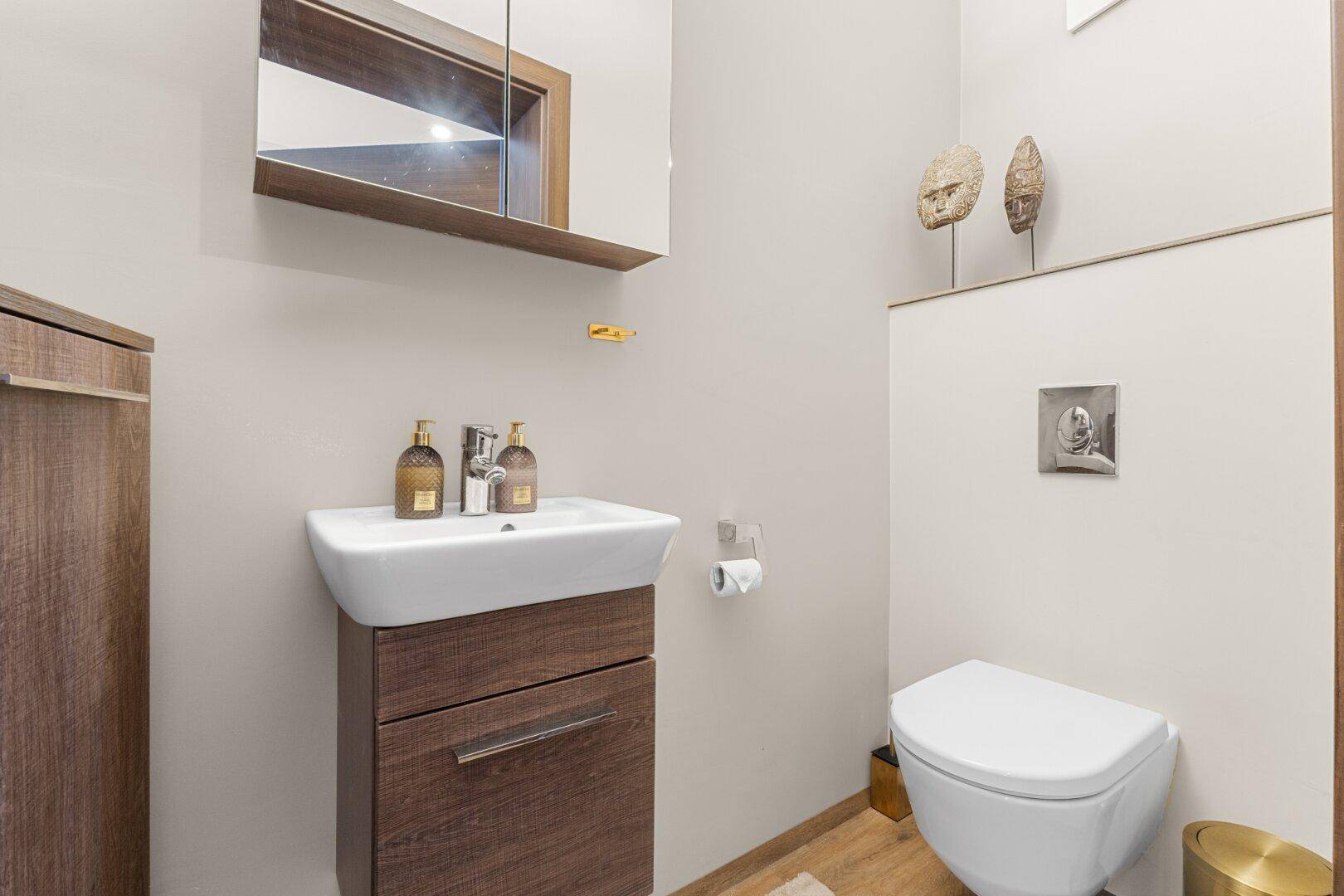 Kleines Gäste-WC mit modernem Waschtisch und Wand-WC.