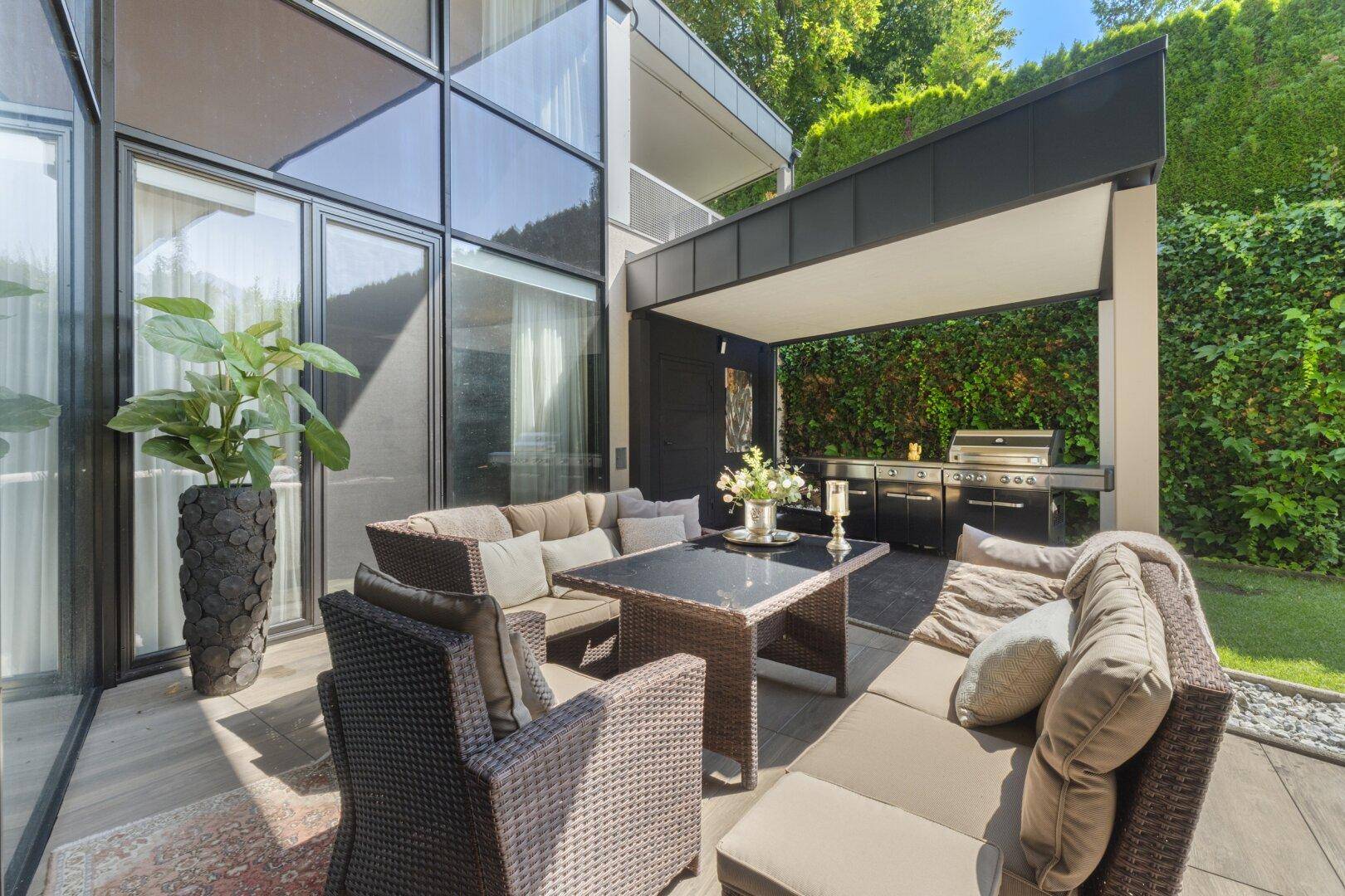 Große Terrasse mit gemütlicher Sitzecke und integriertem Grillbereich.