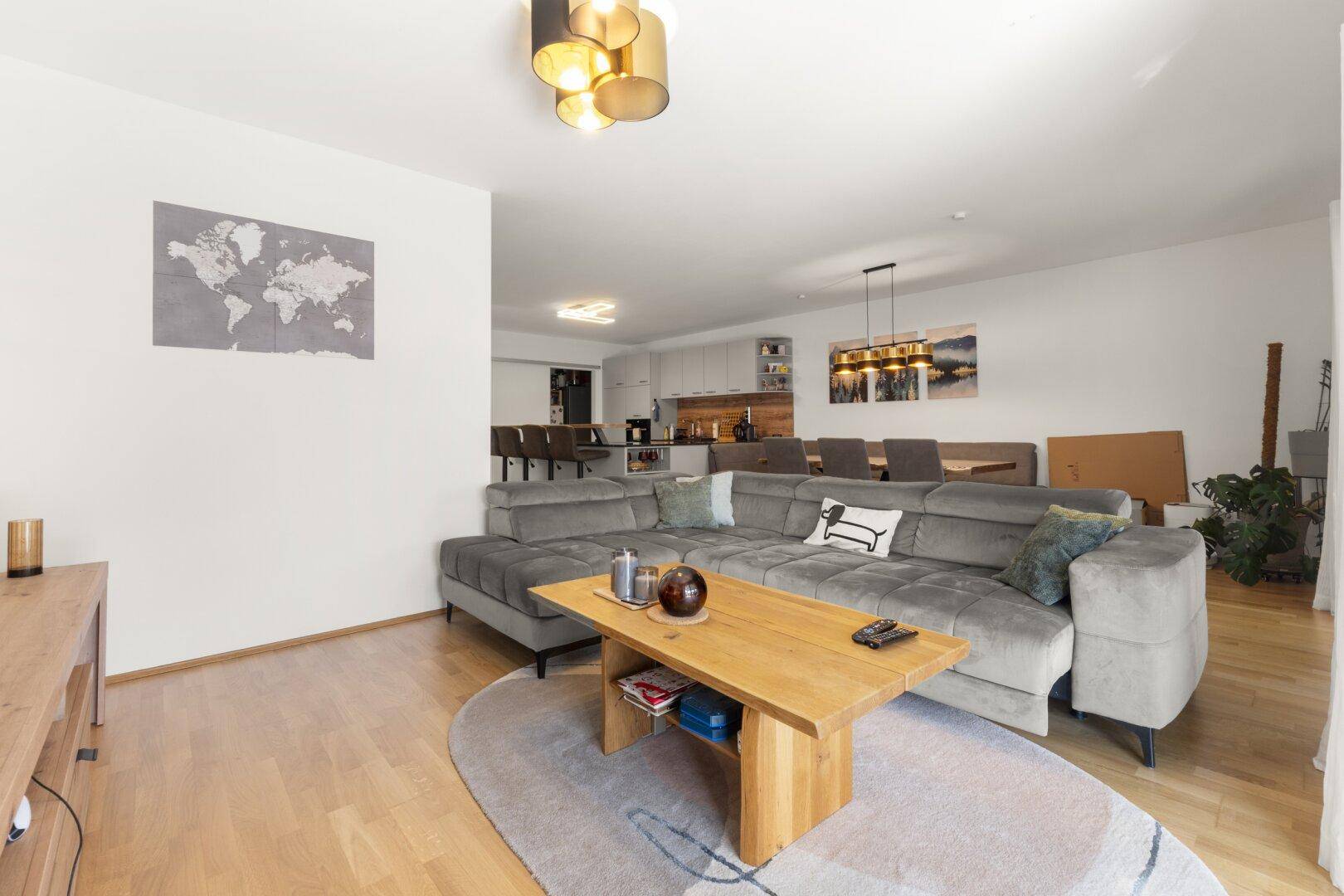 Gemütlicher Wohnbereich mit großem Ecksofa, Holztisch und offener Gestaltung zum Essbereich.