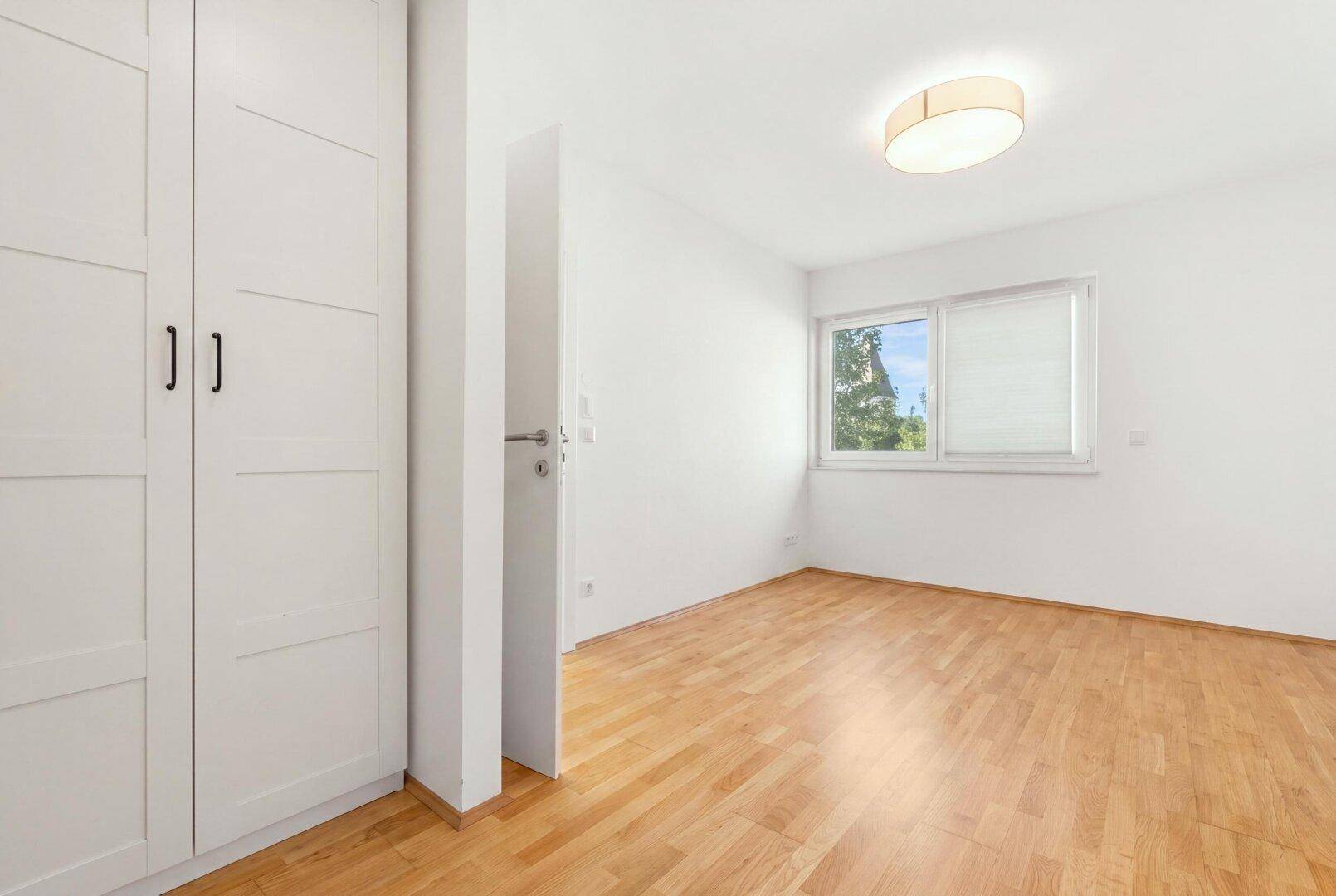 Leeres Zimmer mit Einbauschrank und hellem Holzboden, ideal als Kinder- oder Gästezimmer.