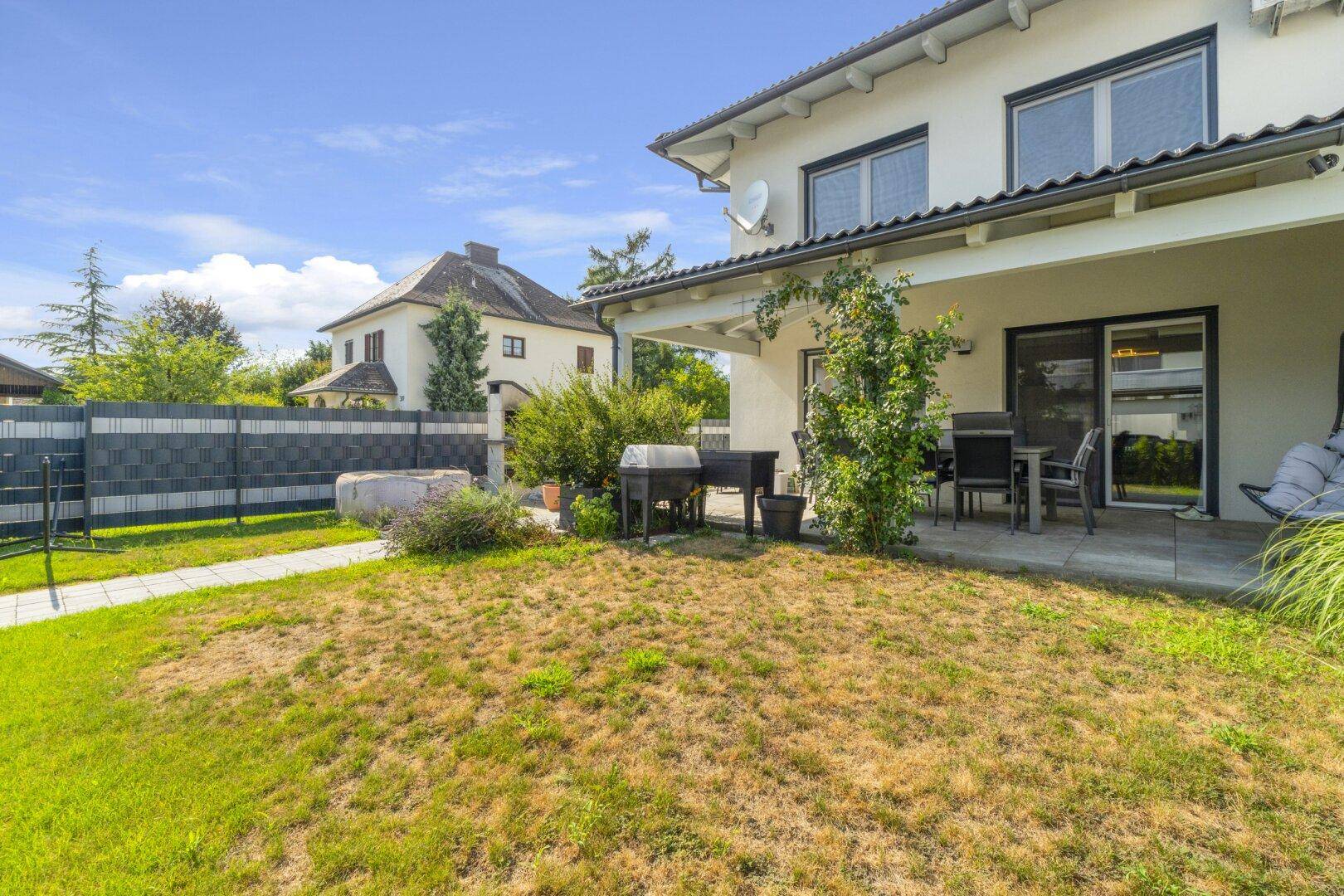 Garten mit Terrasse, Grillplatz und Sitzgelegenheiten für entspannte Stunden im Freien.