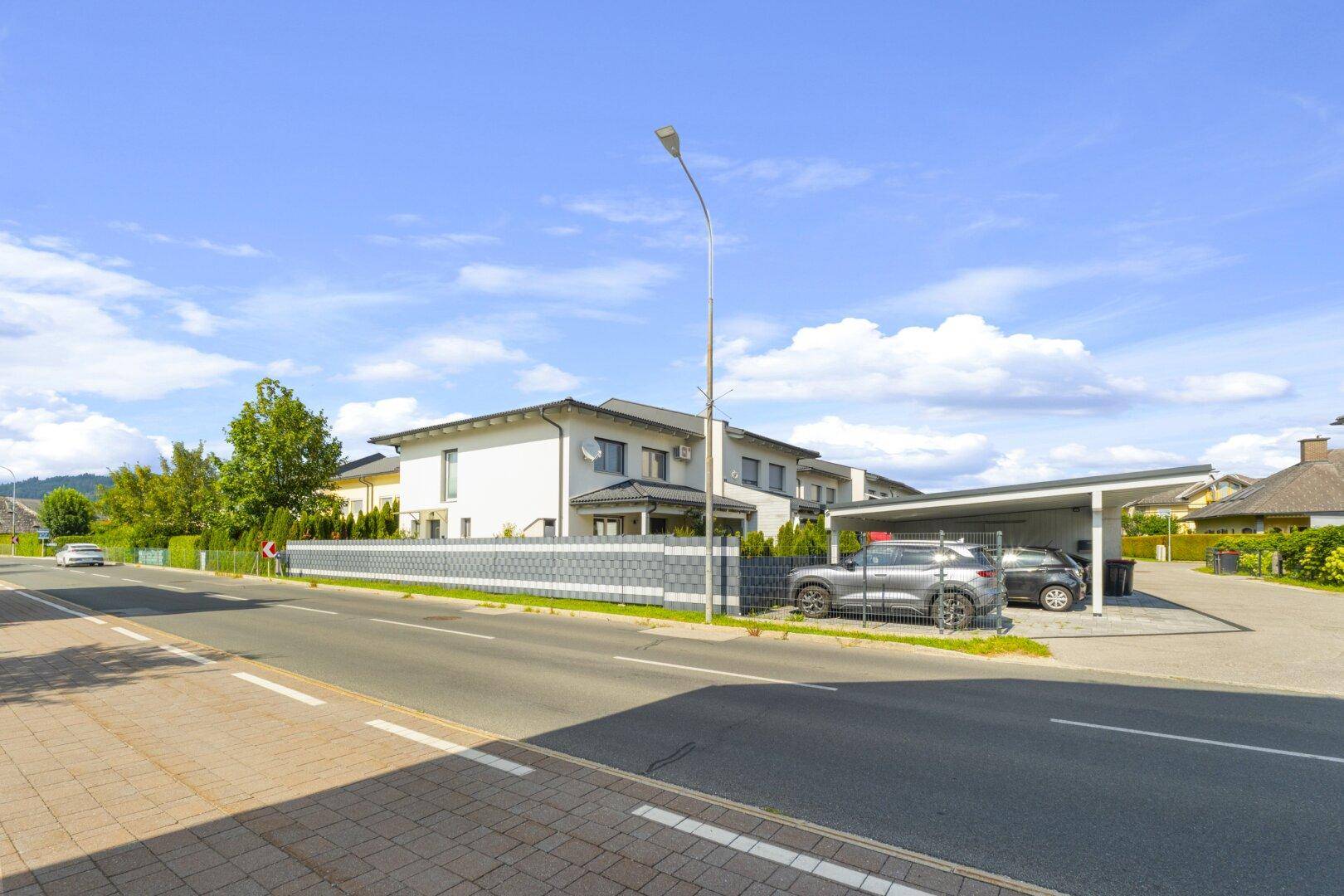 Ansicht des Hauses von der Straße mit Carport und gepflegter Umgebung.