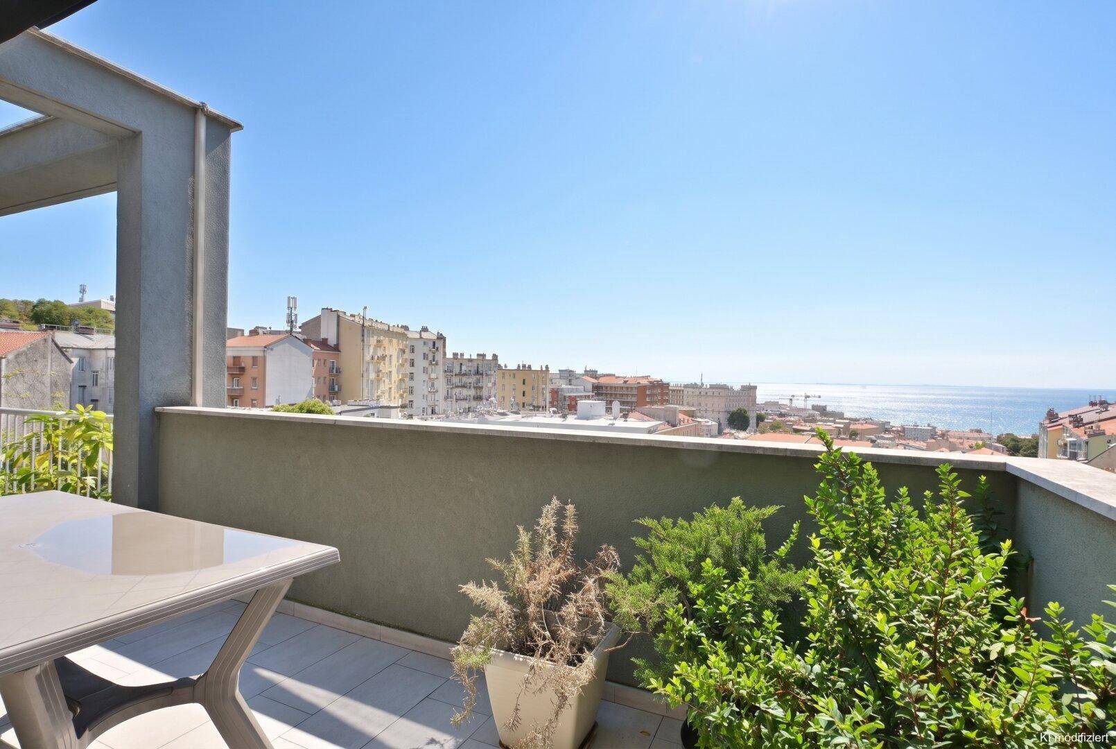 Gemütlicher Balkon mit Meerblick und Topfpflanzen, ideal für entspannte Stunden im Freien.