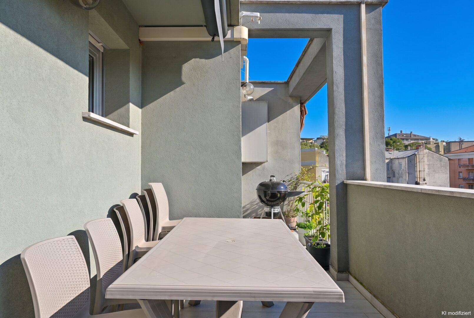 Geräumiger Balkon mit Esstisch und Grill, perfekt für Mahlzeiten im Freien.