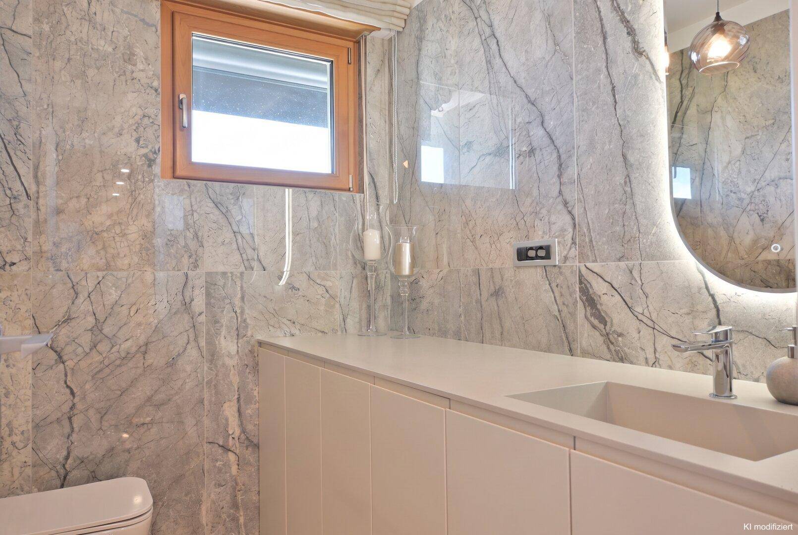 Modernes Badezimmer mit Marmorfliesen, Einzelwaschbecken und Fenster für Tageslicht.