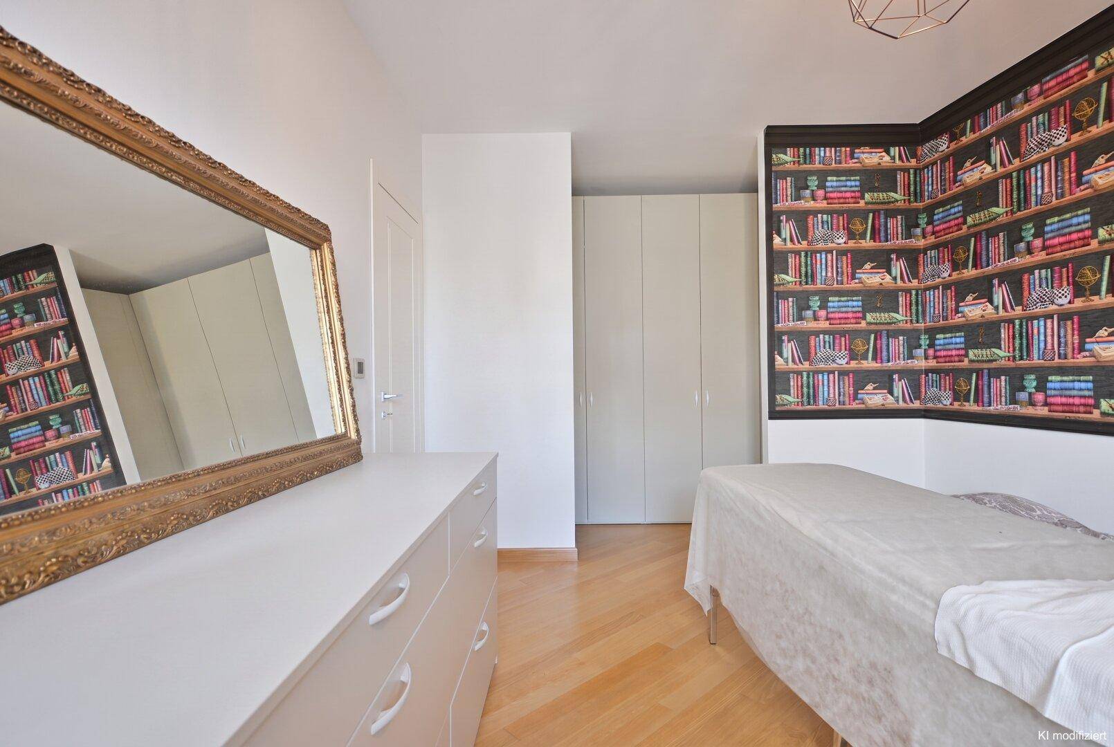 Schlafzimmer mit auffälliger Bücherregal-Tapete, großem Spiegel und Einbauschränken.