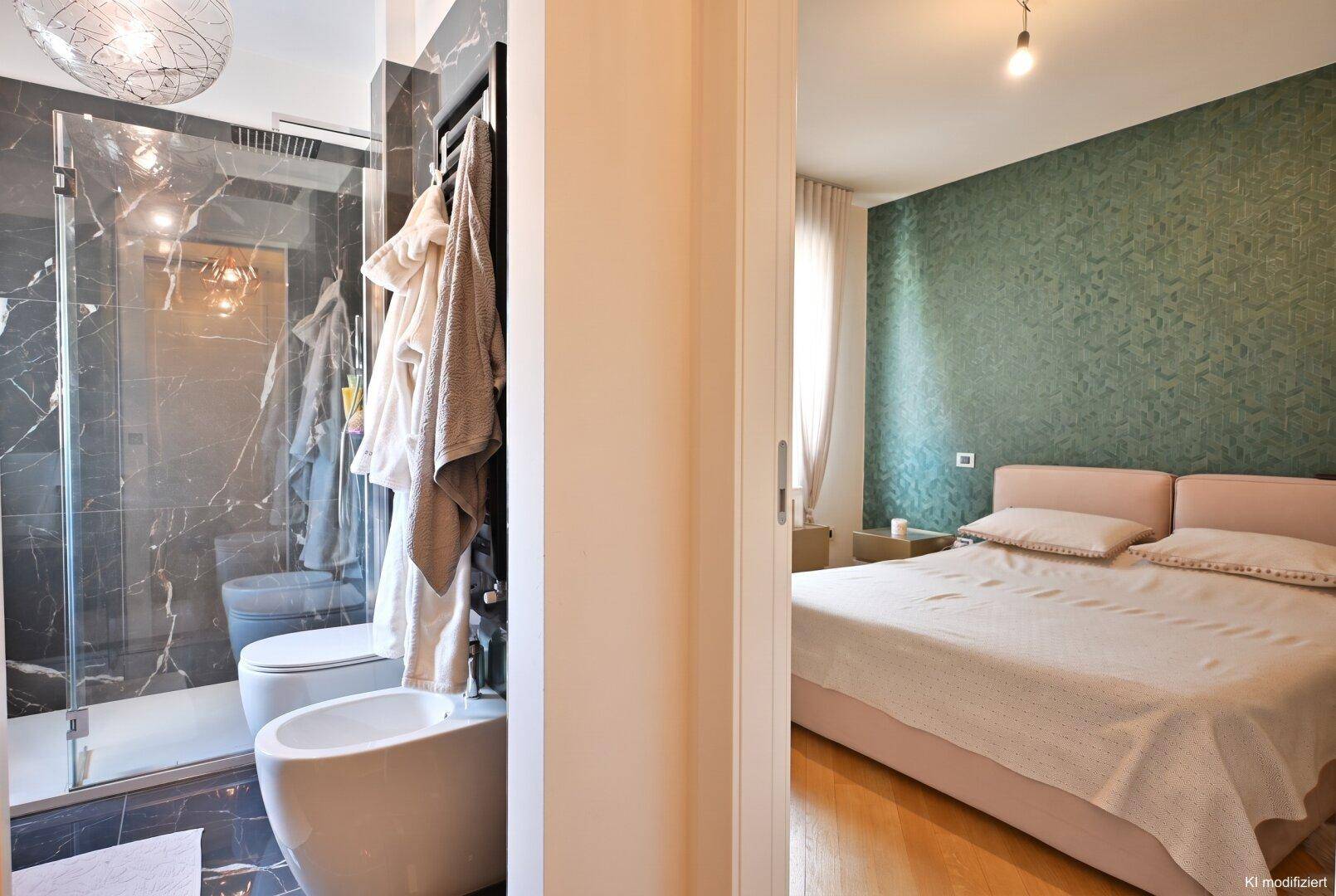 Modernes Badezimmer mit begehbarer Dusche und Bidet, angrenzend an ein Schlafzimmer.
