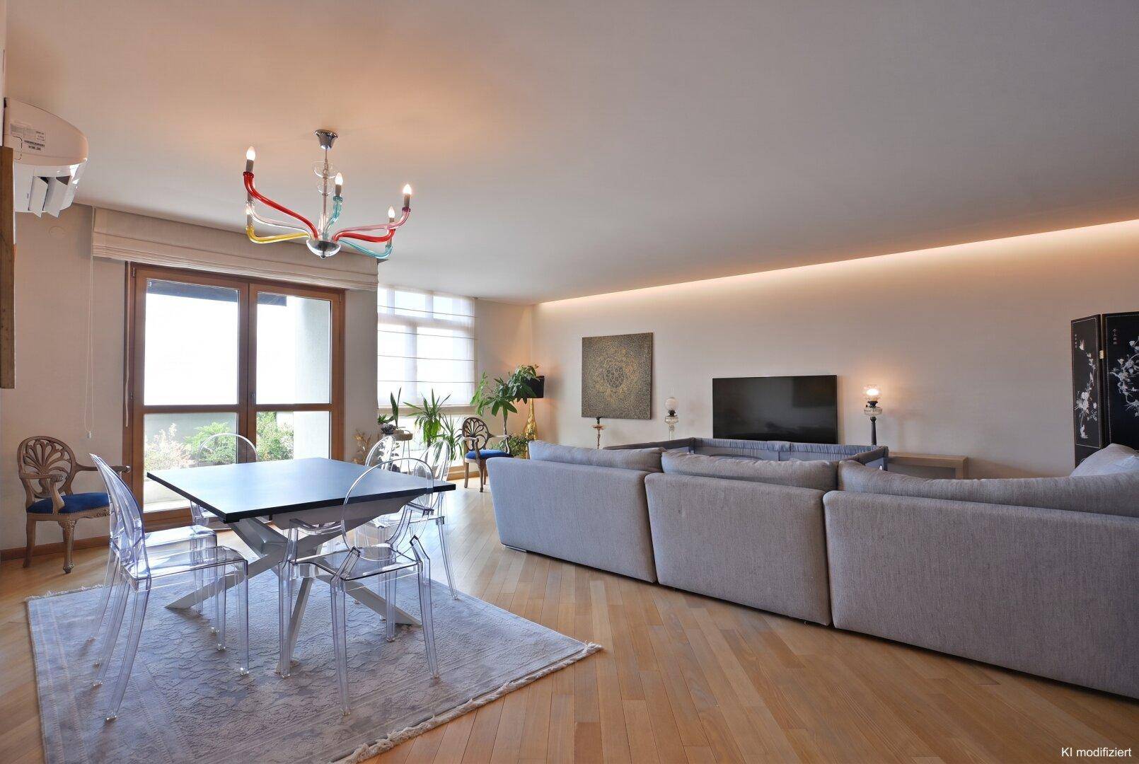Offener Wohn-Essbereich mit Holzboden, großem Esstisch und Zugang zu einem Balkon.