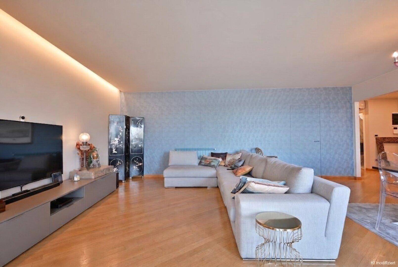 Geräumiges Wohnzimmer mit Ecksofa, Holzboden und integrierter Beleuchtung für eine gemütliche Atmosphäre.