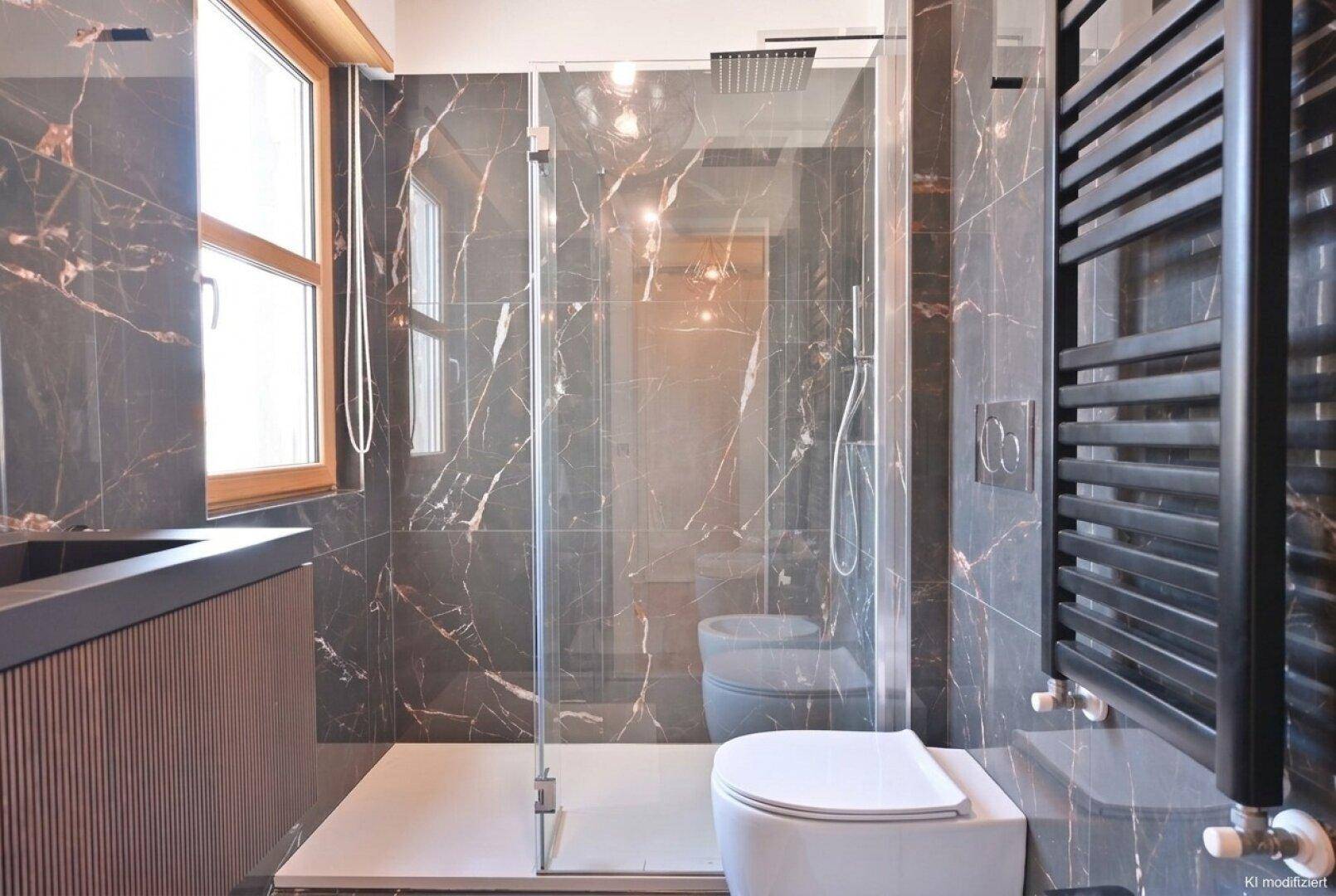 Stilvolles Badezimmer mit dunklen Marmorfliesen, großer begehbarer Dusche und beheiztem Handtuchhalter.