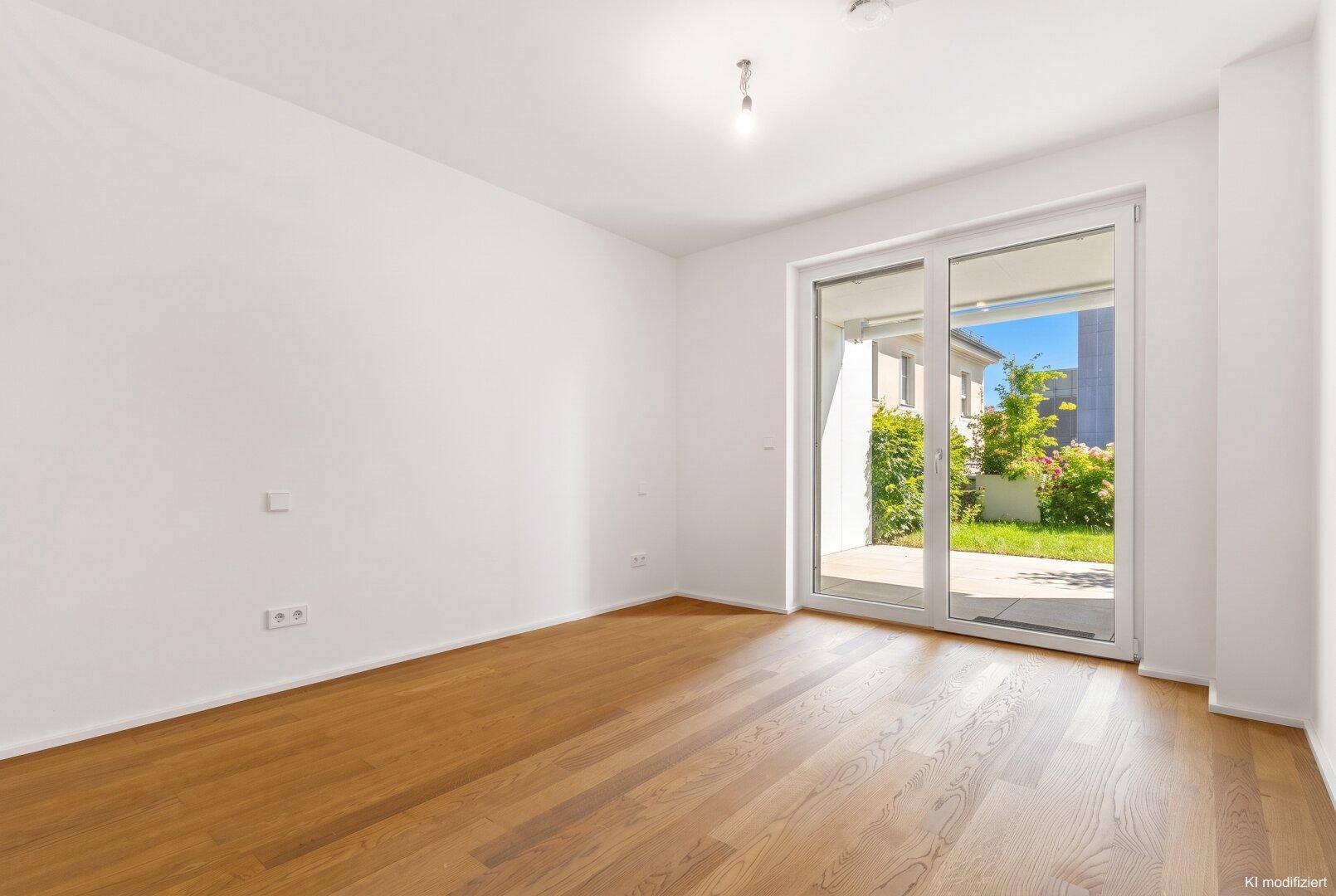 Helles Schlafzimmer mit Parkettboden und direktem Zugang zum privaten Garten.