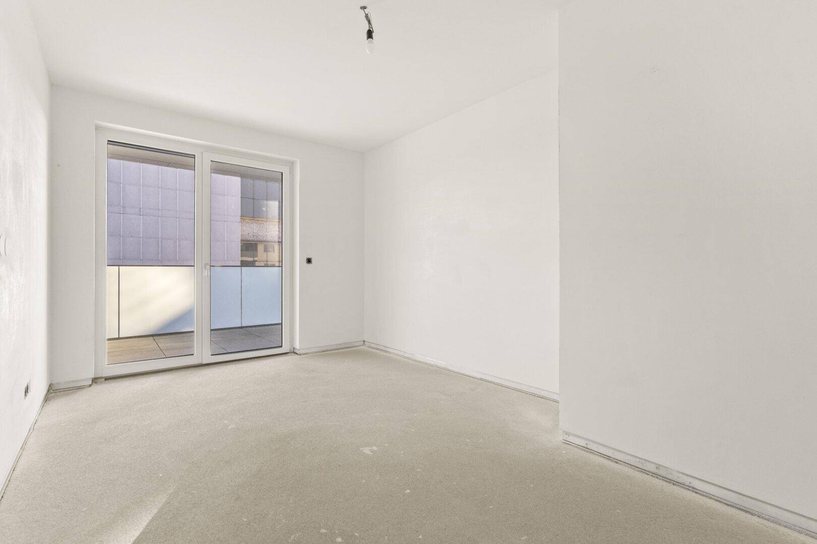Geräumiges Zimmer mit Balkonzugang und hellen Wänden, bereit für die individuelle Gestaltung und Einrichtung.