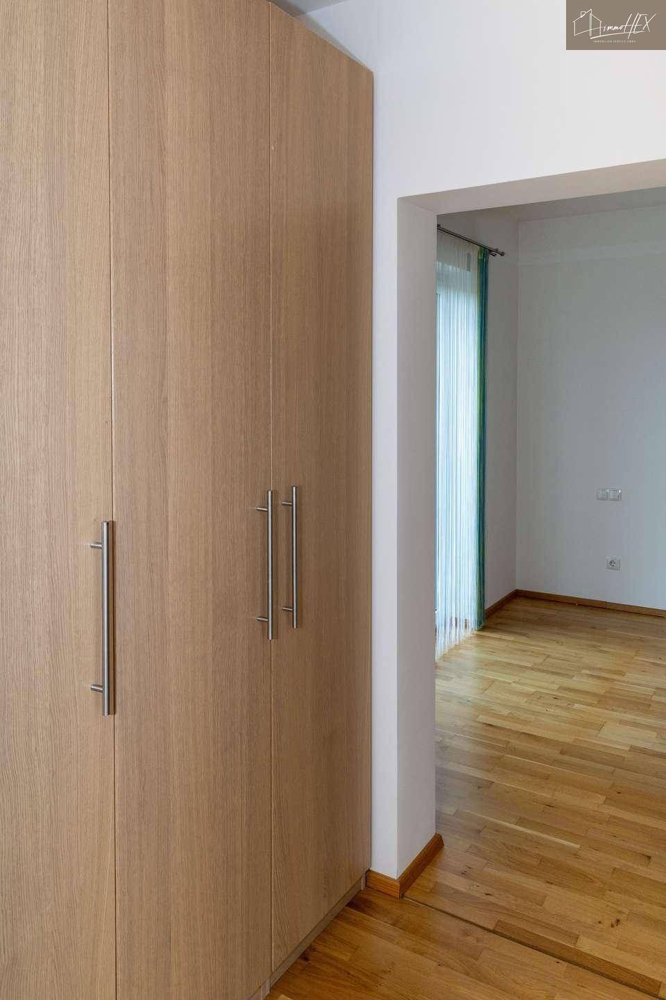Praktische Einbauschränke aus Holz im Flur, bieten diskreten Stauraum.