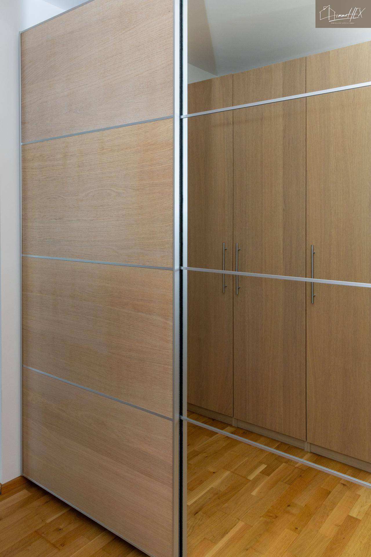 Detailansicht der modernen Einbauschränke mit Spiegeltüren im Flurbereich.