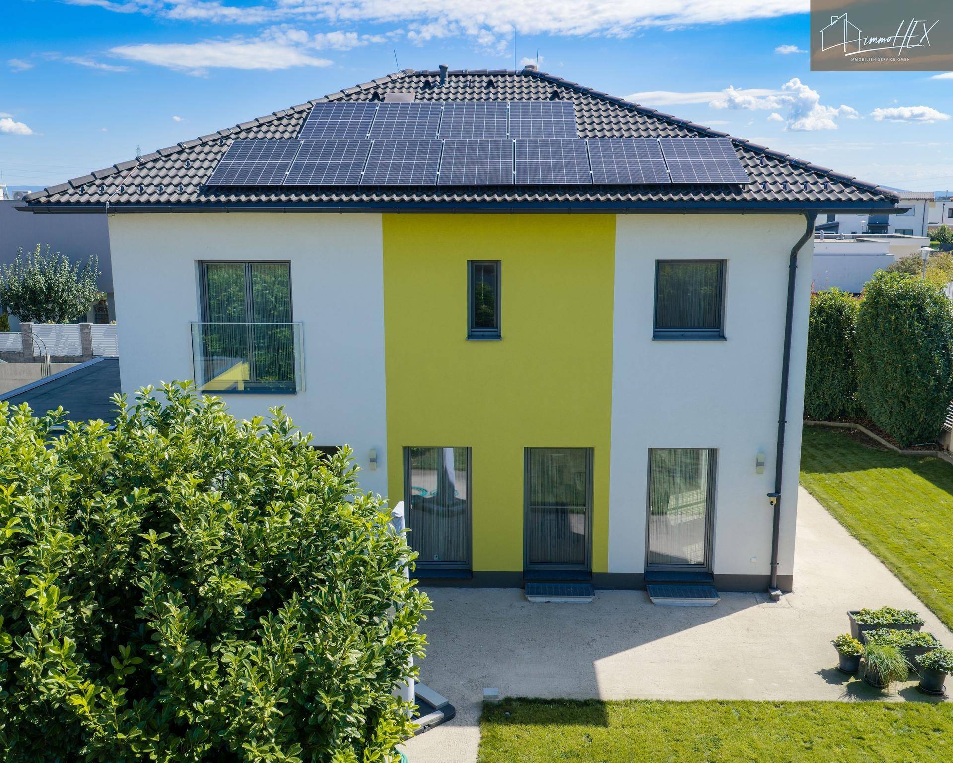 Vogelperspektive des Hauses mit großem Garten, Terrasse und Solaranlage auf dem Satteldach.