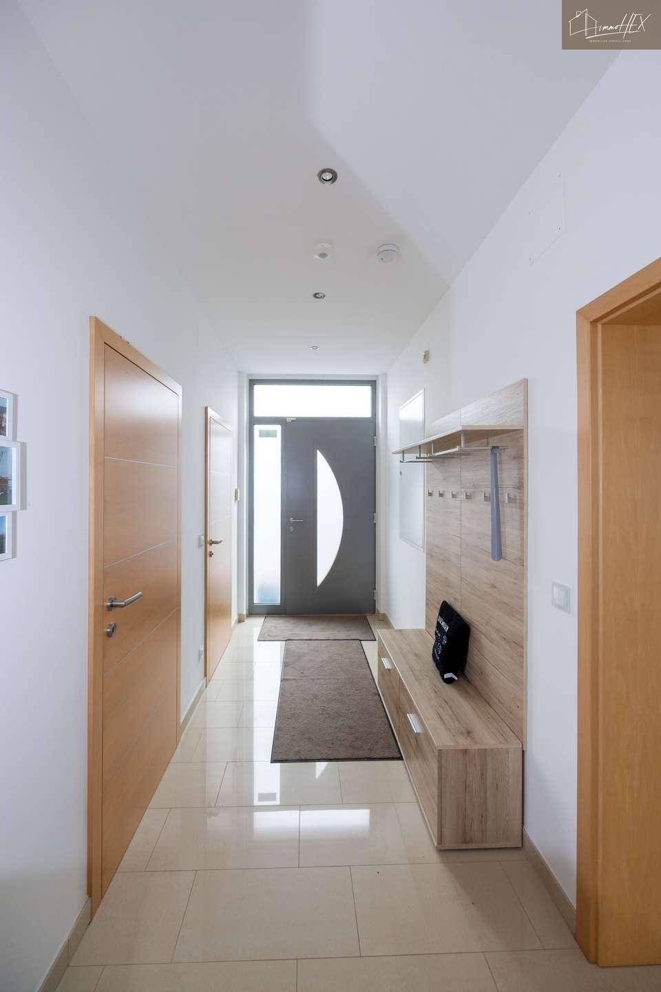 Heller Eingangsbereich mit moderner Garderobe und Fliesenboden, einladend gestaltet.