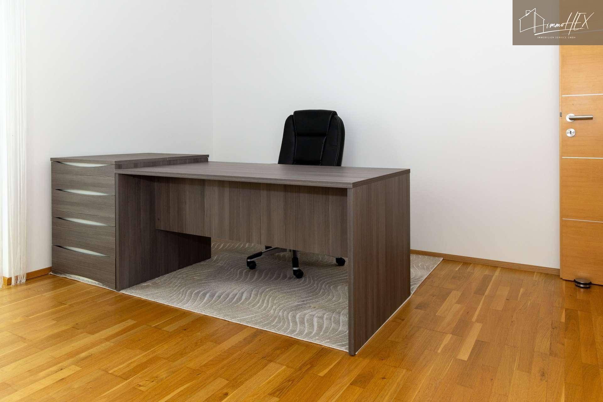 Moderner Schreibtisch mit Bürostuhl und Teppich im Arbeitszimmer, ideal für produktives Arbeiten.