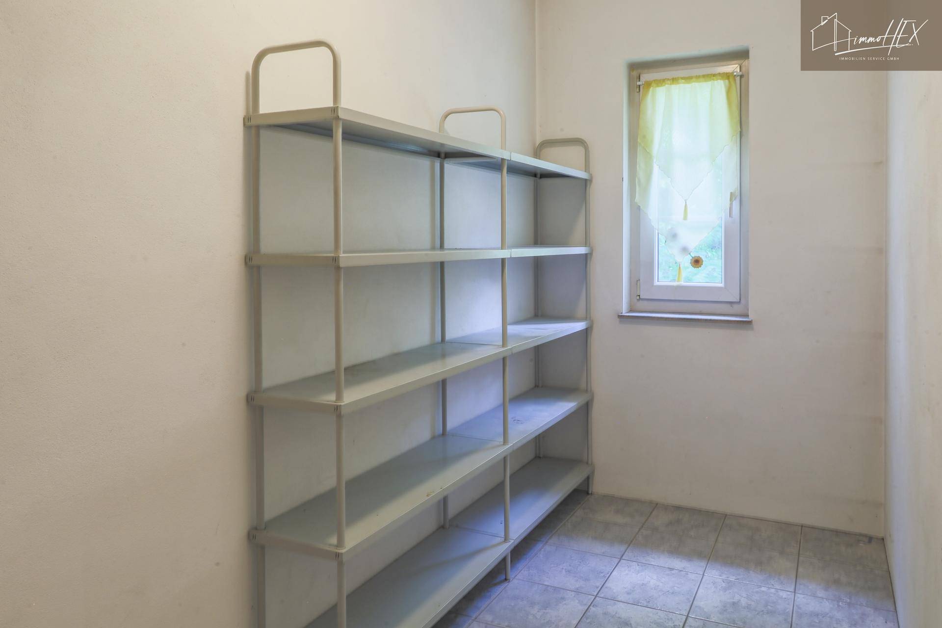 Praktischer Abstellraum mit Regalsystem und Fenster für zusätzlichen Stauraum.
