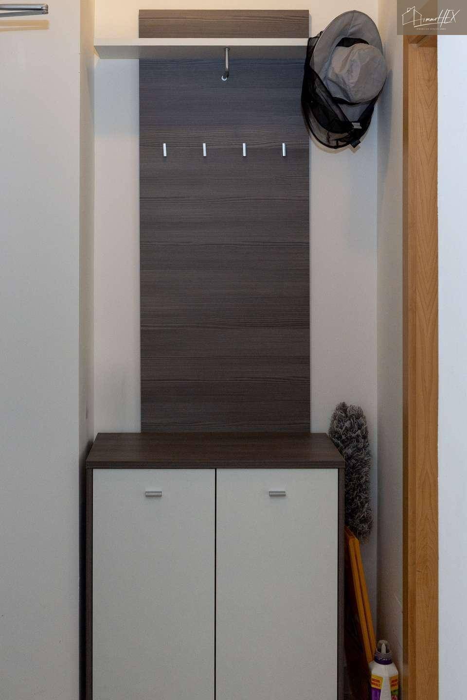 Moderner Garderobenbereich mit Schuhschrank und Kleiderhaken im Eingangsbereich.