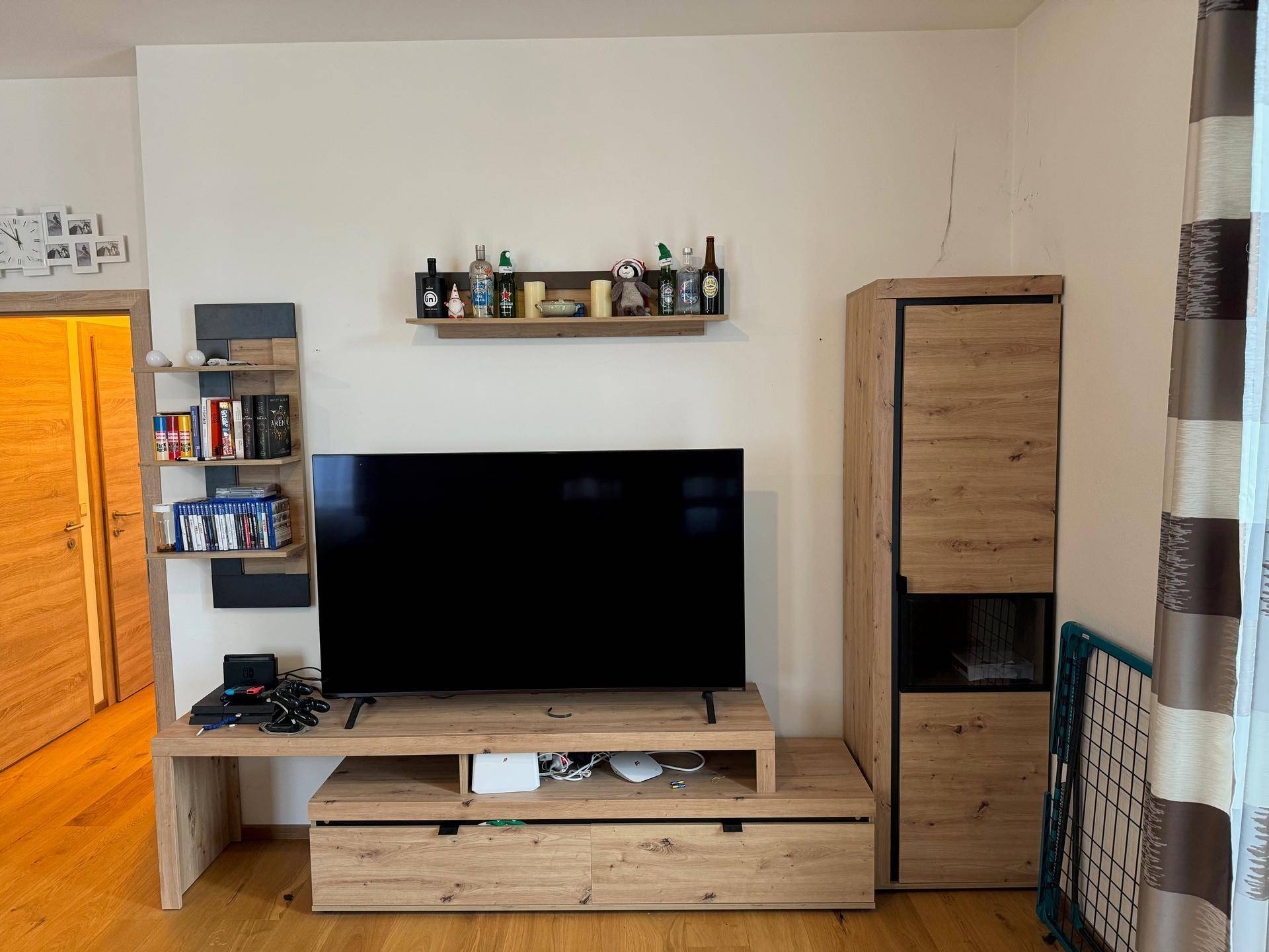 Moderner TV-Bereich mit Holzmöbeln und Wandregalen im Wohnzimmer.