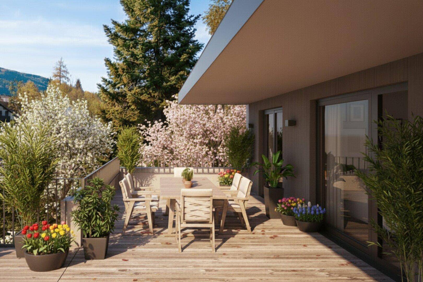 Geräumige Terrasse mit Holzboden, Esstisch und Blick auf die umliegende Natur und Berge.