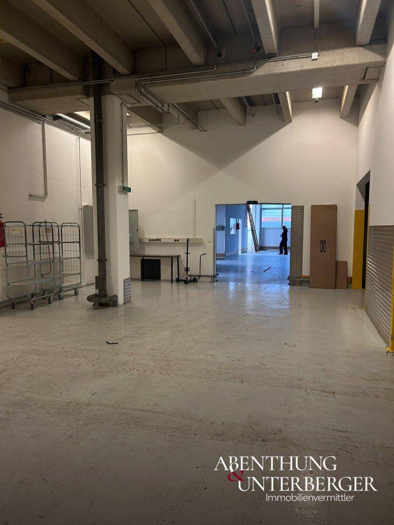 Innenansicht der Industriehalle mit Blick auf einen offenen Durchgang zu einem weiteren Bereich.
