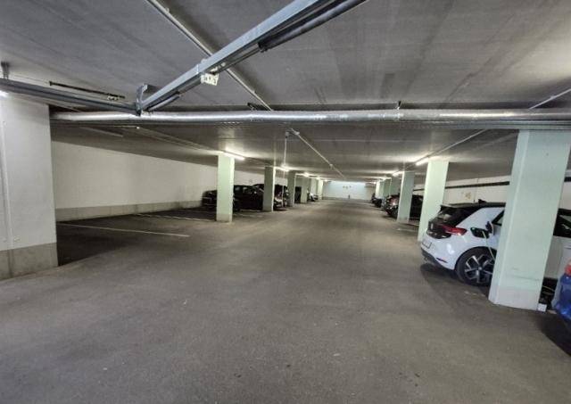 Geräumige Tiefgarage mit mehreren Stellplätzen und guter Beleuchtung für Bewohner.