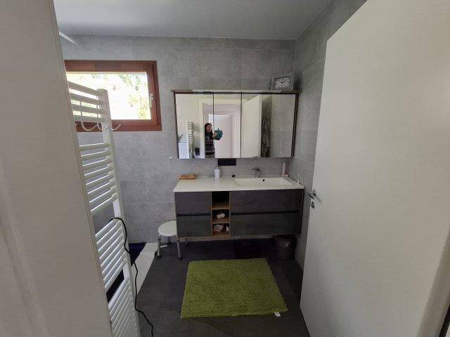 Modernes Badezimmer mit Doppelwaschbecken, großem Spiegelschrank und Fenster.