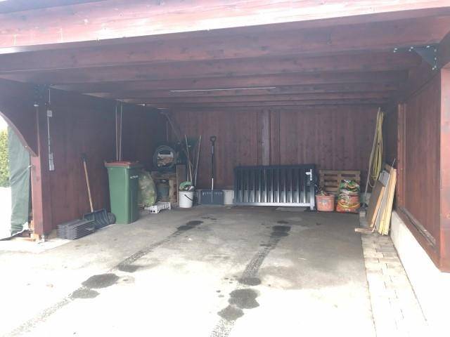 Überdachter Carport oder Garage mit Platz für Fahrzeuge und Lagerung.