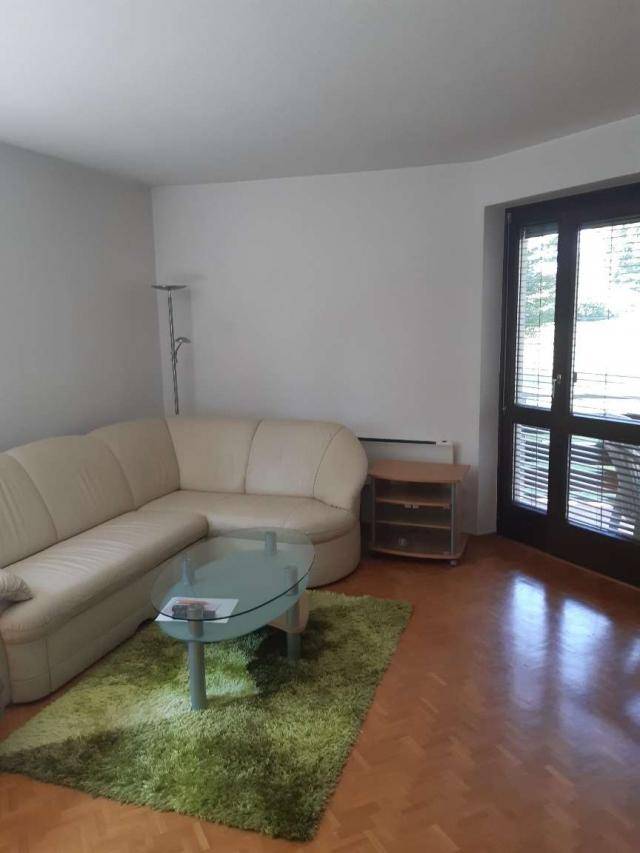 Helles Wohnzimmer mit beigem Ecksofa, Glastisch und Zugang zur Terrasse für entspannte Stunden.