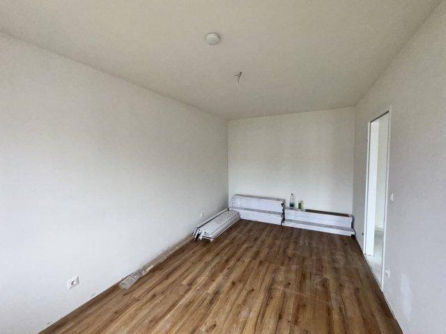 Zimmer im Neubau mit neu verlegtem Laminatboden und weißen Wänden, bereit zum Einzug.