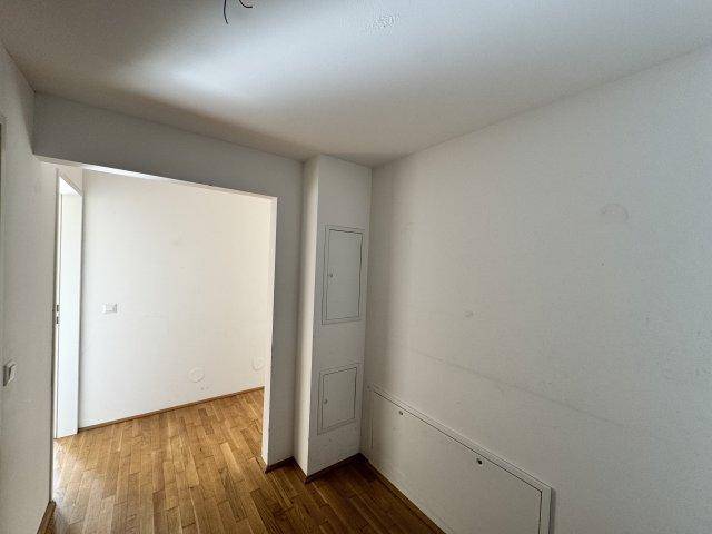 Eingangsbereich oder Flur mit hellem Holzboden und weißen Wänden, schlicht gestaltet.