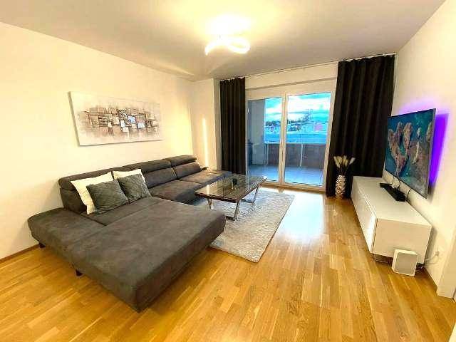 Gemütlicher Wohnbereich mit großem Ecksofa, Fernseher und Blick auf den Balkon.