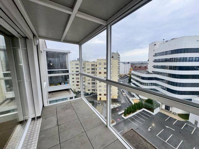 Verglaste Loggia mit Fliesenboden und weitem Blick über die Stadt.