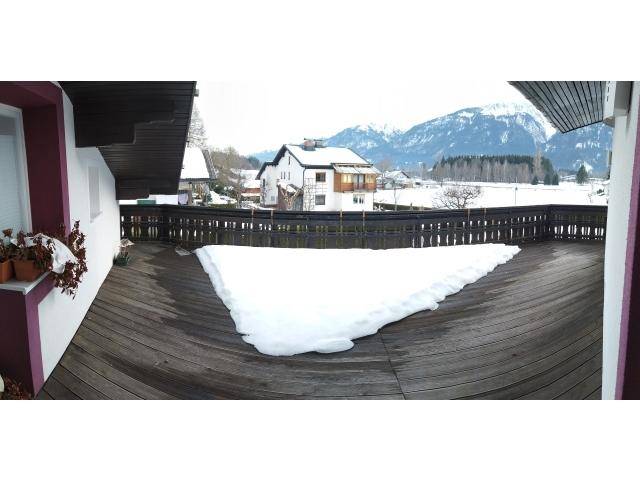 Große Holzterrasse mit Bergblick und Schnee im Winter.
