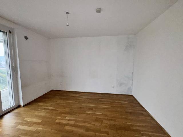 Leerer Raum mit Holzboden und weiß gestrichenen Wänden, bereit zur individuellen Gestaltung.