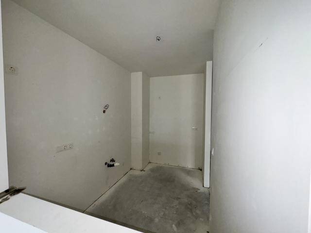 Kleiner, unfertiger Raum mit sichtbaren Sanitäranschlüssen, ideal für ein Gäste-WC oder Bad.