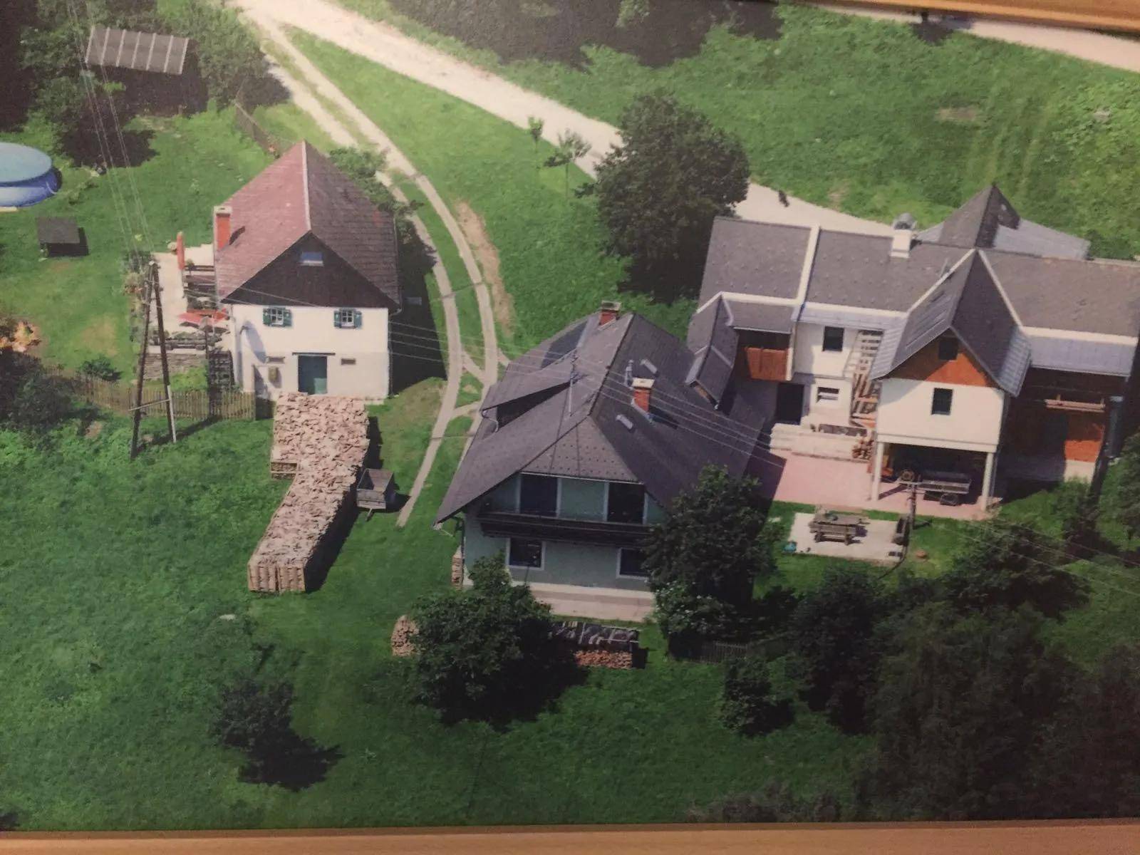Luftaufnahme mehrerer Häuser in ländlicher Umgebung mit viel Grün und einem kleinen Pool.