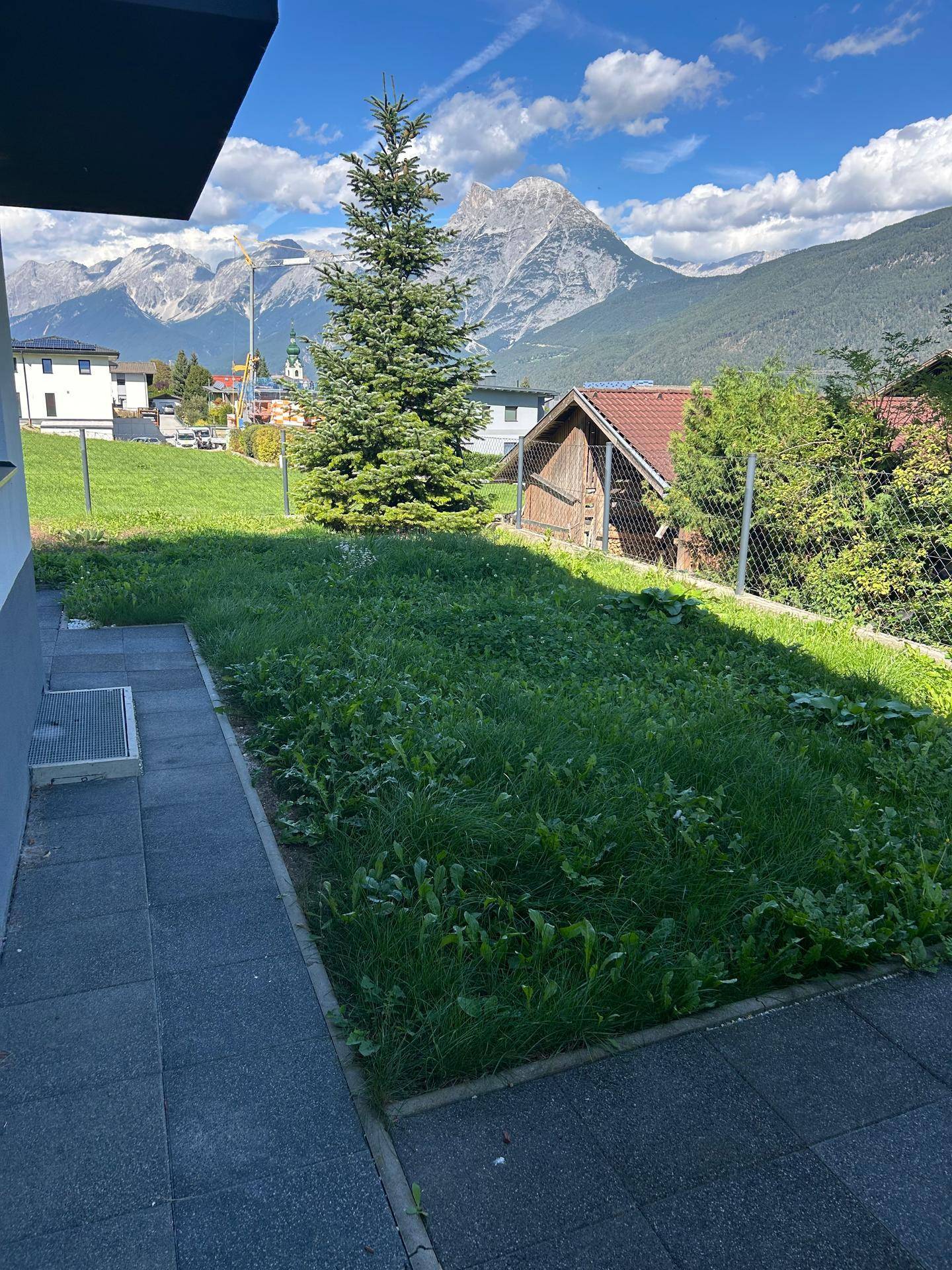 Gepflegter Gartenbereich mit Rasenfläche und Bergblick, ideal zum Entspannen im Freien.