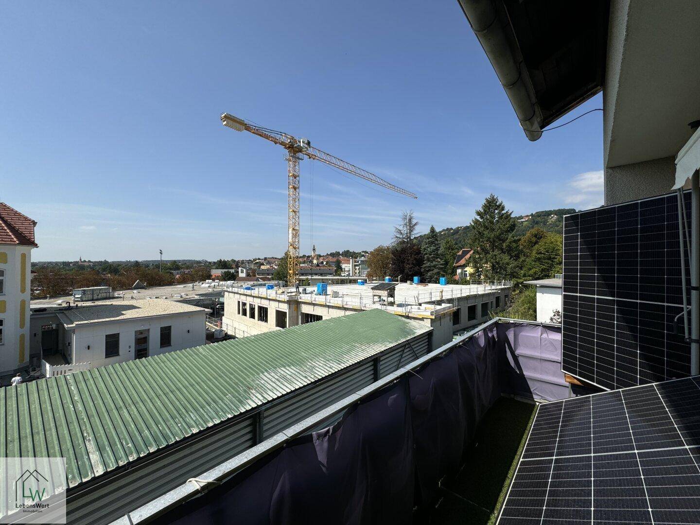 Dachterrasse mit Blick auf die Stadt und eine Baustelle in der Ferne.