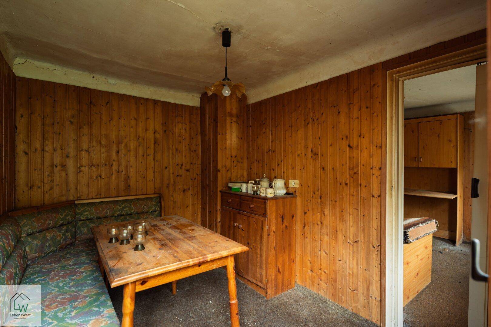 Rustikaler Essbereich mit Holztäfelung, Eckbank und einem Holztisch.
