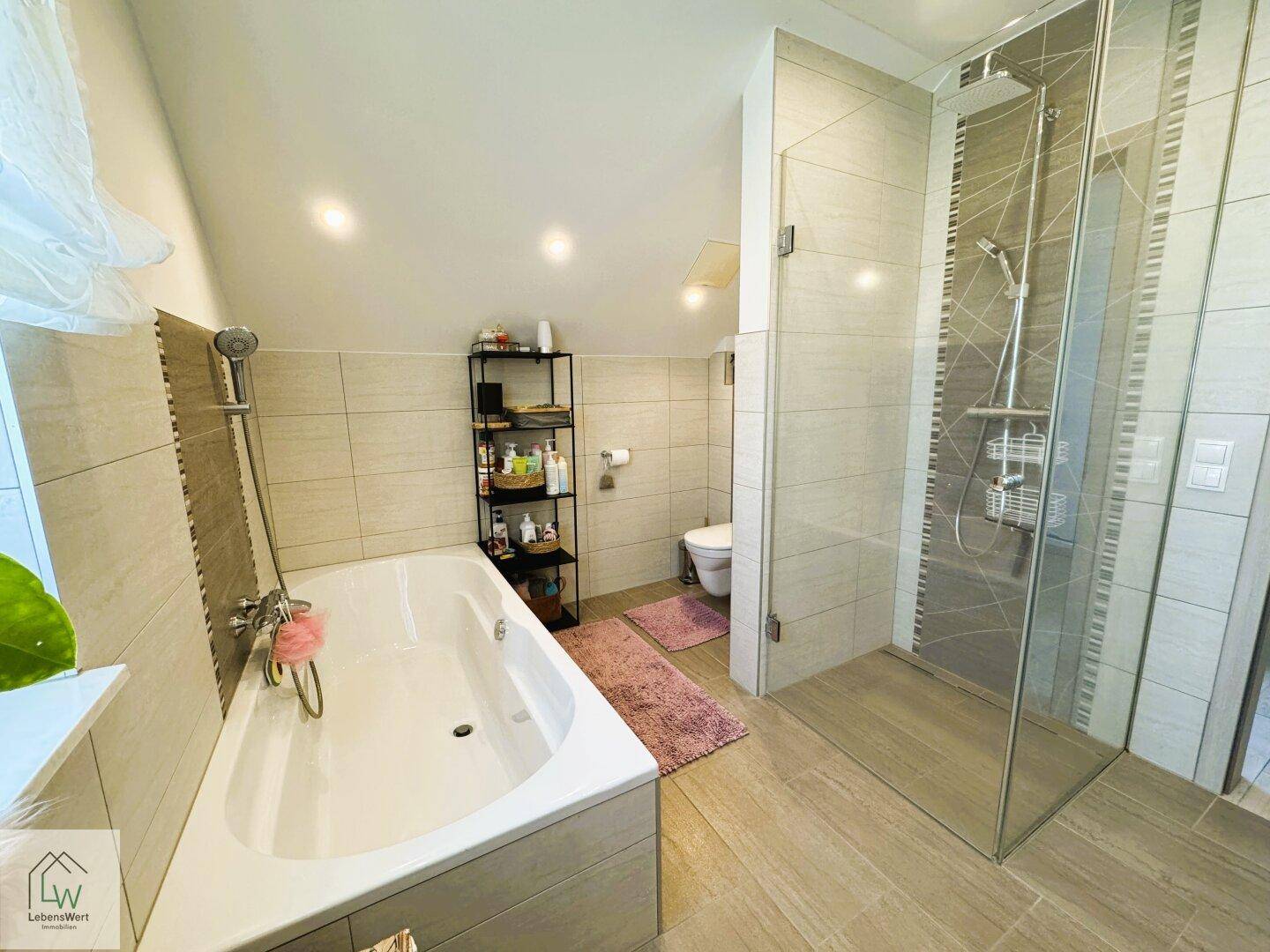 Modernes Badezimmer mit Badewanne, begehbarer Dusche und hellen Fliesen.