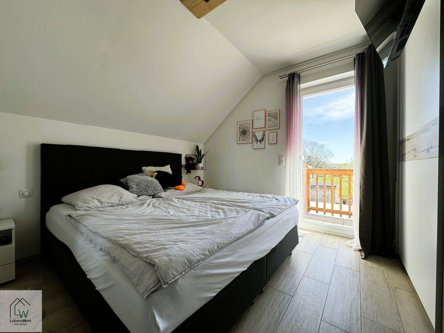 Schlafzimmer mit Doppelbett, Fliesenboden und Zugang zu einem kleinen Balkon.