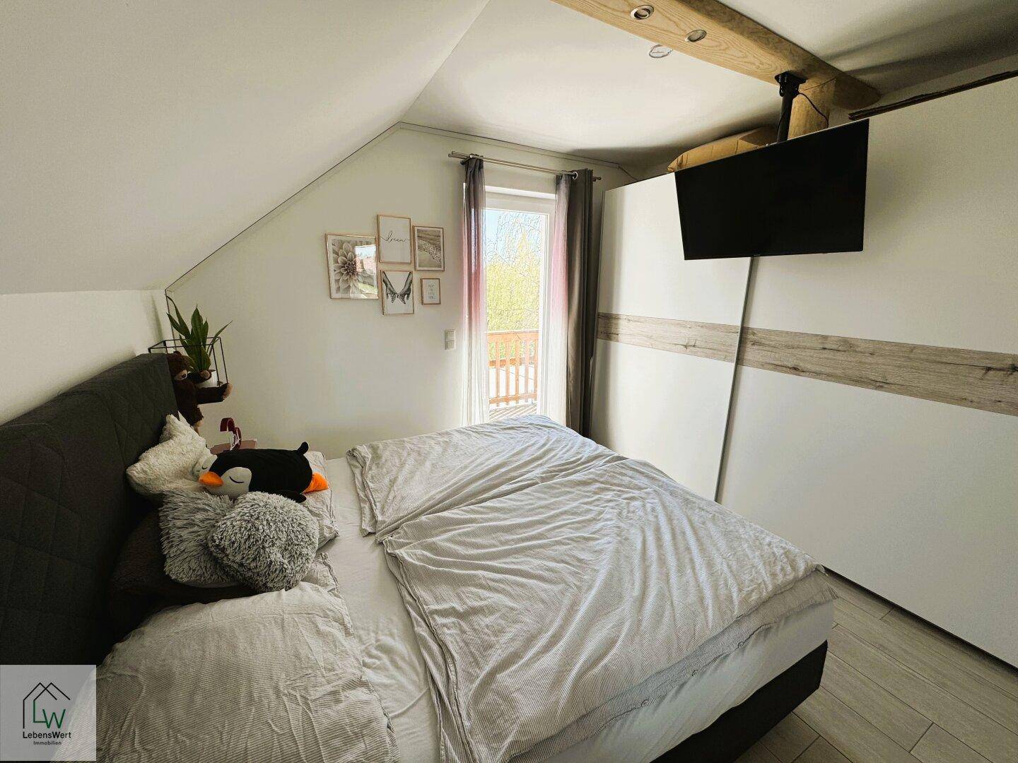 Gemütliches Schlafzimmer mit Doppelbett, Einbauschrank und Zugang zum Balkon.