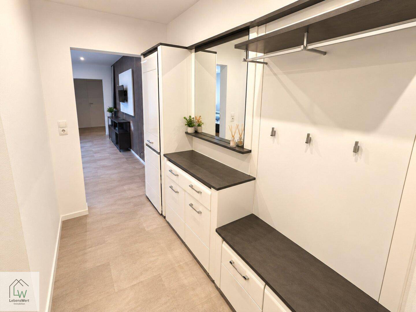 Eingangsbereich mit integrierter Garderobe, Spiegel und praktischen Ablagemöglichkeiten.
