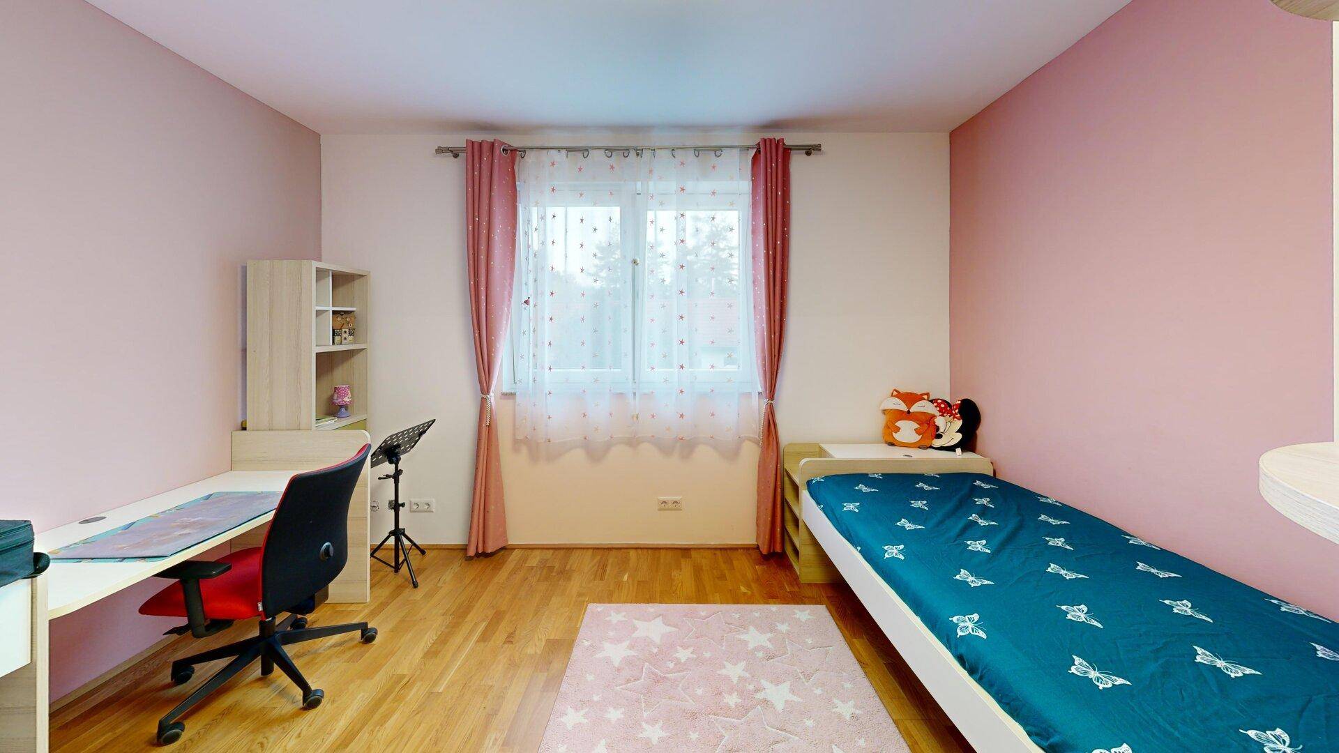 Kinderzimmer mit rosa Wänden, Schreibtisch und Einzelbett, ideal für ein Kind.