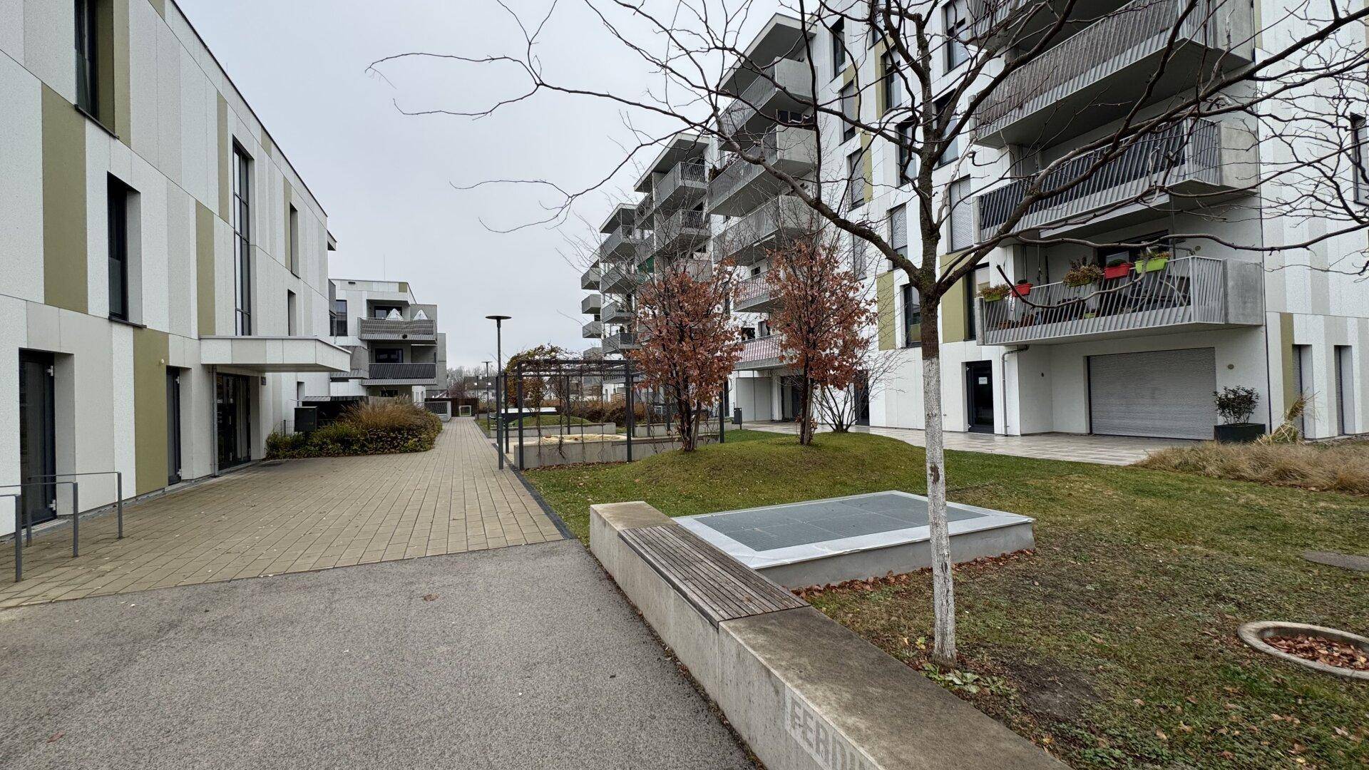 Moderne Wohngebäude mit Balkonen und gepflegten Grünflächen in einer Wohnsiedlung.